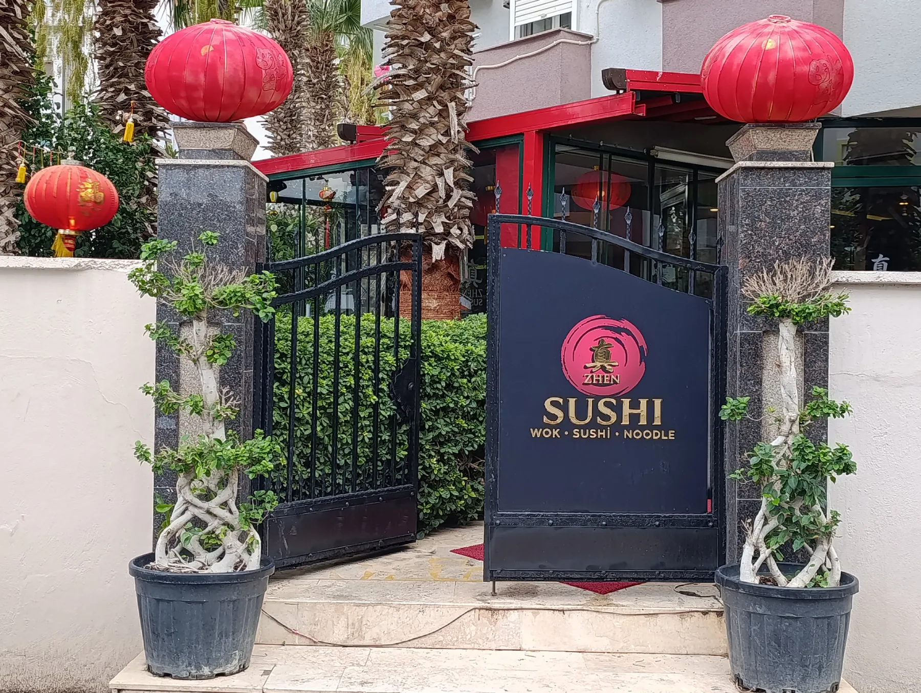 Giriş kapısı, Zhen Sushi tabelası ve kırmızı fenerler